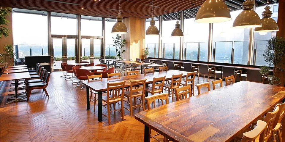 A long café dining room with timber chairs, tables and an upholstered bench